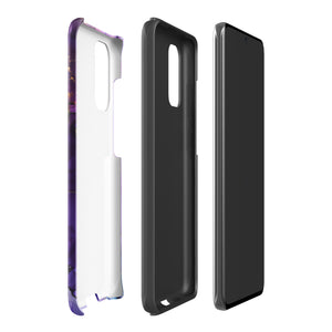 The Golden Orchid Marble for Samsung by Statement Cases is a smartphone adorned with a vibrant, abstract phone case showcasing a mix of purple, pink, and gold colors. Crafted from impact-resistant materials, it features a camera module with four lenses and a flash. At the bottom of the shock-absorbing phone case, you’ll find the text "STATEMENT CASES" in white.