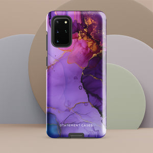 The Golden Orchid Marble for Samsung by Statement Cases is a smartphone adorned with a vibrant, abstract phone case showcasing a mix of purple, pink, and gold colors. Crafted from impact-resistant materials, it features a camera module with four lenses and a flash. At the bottom of the shock-absorbing phone case, you’ll find the text "STATEMENT CASES" in white.