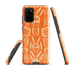 This stylish smartphone accessory, the Savannah Ardiente for Samsung by Statement Cases, features a shock-absorbing, colorful patterned case adorned with abstract flower designs in beige on an orange background. This impact-resistant phone case wraps around the back of your device, providing robust protection for its multiple camera lenses in the corner.