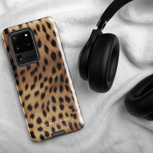 A smartphone with a leopard print, dual-layer design phone case featuring four camera lenses on the back is displayed against a white background. The bottom of the tough phone case has the brand name "Statement Cases" in white letters. The product name is "Daring Cheetah Fur for Samsung".