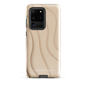 A Sandy Serenity for Samsung encased in a beige, impact-resistant phone case with wavy, textured patterns. Four camera lenses are visible on the back. The lower part of the dual-layer design case displays the text "Statement Cases.