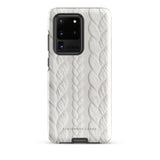 A stylish, impact-resistant phone case with a textured white braided design, covering the back of a smartphone. The dual-layer design features cutouts for the camera and buttons, and "Cozy Knit Bliss for Samsung" by Statement Cases is embossed at the bottom.