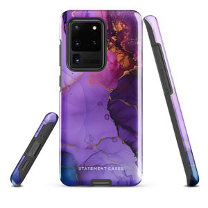 The Golden Orchid Marble for Samsung by Statement Cases is a smartphone adorned with a vibrant, abstract phone case showcasing a mix of purple, pink, and gold colors. Crafted from impact-resistant materials, it features a camera module with four lenses and a flash. At the bottom of the shock-absorbing phone case, you’ll find the text "STATEMENT CASES" in white.