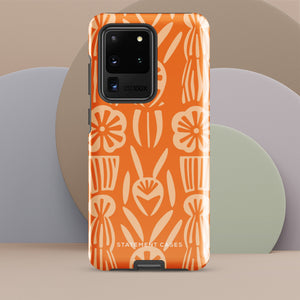 This stylish smartphone accessory, the Savannah Ardiente for Samsung by Statement Cases, features a shock-absorbing, colorful patterned case adorned with abstract flower designs in beige on an orange background. This impact-resistant phone case wraps around the back of your device, providing robust protection for its multiple camera lenses in the corner.