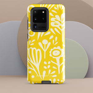 The Sol Dorado for Samsung by Statement Cases is a durable phone case featuring a bright yellow background adorned with an abstract white floral pattern, showcasing various flowers and leaves. Near the bottom edge, the text "STATEMENT CASE" highlights its dual-layer design for enhanced durability.