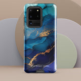 A Samsung smartphone adorned with the Midnight Wave Marble—a vibrant, blue and gold marble-patterned dual-layer phone case. Featuring multiple camera lenses at the top left corner, this impact-resistant case is elegantly labeled "Statement Cases" in white text at the bottom. The design showcases fluid, swirling layers with metallic accents.