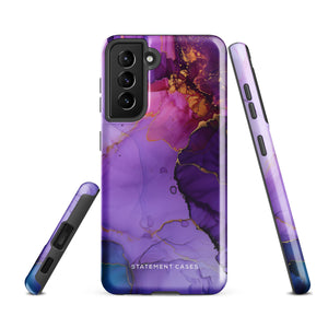 The Golden Orchid Marble for Samsung by Statement Cases is a smartphone adorned with a vibrant, abstract phone case showcasing a mix of purple, pink, and gold colors. Crafted from impact-resistant materials, it features a camera module with four lenses and a flash. At the bottom of the shock-absorbing phone case, you’ll find the text "STATEMENT CASES" in white.