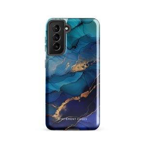 A Samsung smartphone adorned with the Midnight Wave Marble—a vibrant, blue and gold marble-patterned dual-layer phone case. Featuring multiple camera lenses at the top left corner, this impact-resistant case is elegantly labeled "Statement Cases" in white text at the bottom. The design showcases fluid, swirling layers with metallic accents.