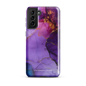 The Golden Orchid Marble for Samsung by Statement Cases is a smartphone adorned with a vibrant, abstract phone case showcasing a mix of purple, pink, and gold colors. Crafted from impact-resistant materials, it features a camera module with four lenses and a flash. At the bottom of the shock-absorbing phone case, you’ll find the text "STATEMENT CASES" in white.