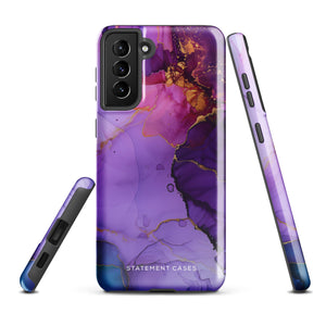 The Golden Orchid Marble for Samsung by Statement Cases is a smartphone adorned with a vibrant, abstract phone case showcasing a mix of purple, pink, and gold colors. Crafted from impact-resistant materials, it features a camera module with four lenses and a flash. At the bottom of the shock-absorbing phone case, you’ll find the text "STATEMENT CASES" in white.