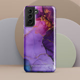 The Golden Orchid Marble for Samsung by Statement Cases is a smartphone adorned with a vibrant, abstract phone case showcasing a mix of purple, pink, and gold colors. Crafted from impact-resistant materials, it features a camera module with four lenses and a flash. At the bottom of the shock-absorbing phone case, you’ll find the text "STATEMENT CASES" in white.