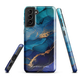 A Samsung smartphone adorned with the Midnight Wave Marble—a vibrant, blue and gold marble-patterned dual-layer phone case. Featuring multiple camera lenses at the top left corner, this impact-resistant case is elegantly labeled "Statement Cases" in white text at the bottom. The design showcases fluid, swirling layers with metallic accents.