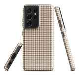 A Samsung smartphone with a beige and brown houndstooth patterned, impact-resistant case from Statement Cases. The phone features multiple cameras on the upper left side of its back. This tough Classic Houndstooth for Samsung phone case has a sleek, dual-layer design with precise cutouts for the cameras and buttons.
