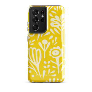 The Sol Dorado for Samsung by Statement Cases is a durable phone case featuring a bright yellow background adorned with an abstract white floral pattern, showcasing various flowers and leaves. Near the bottom edge, the text "STATEMENT CASE" highlights its dual-layer design for enhanced durability.