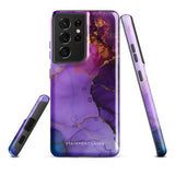 The Golden Orchid Marble for Samsung by Statement Cases is a smartphone adorned with a vibrant, abstract phone case showcasing a mix of purple, pink, and gold colors. Crafted from impact-resistant materials, it features a camera module with four lenses and a flash. At the bottom of the shock-absorbing phone case, you’ll find the text "STATEMENT CASES" in white.