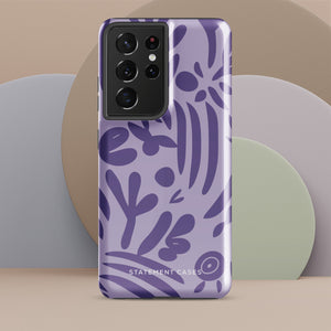 Introducing the Luna Morada for Samsung, a striking smartphone case from Statement Cases. This decorative purple cover boasts abstract floral and organic patterns in darker hues and is designed to absorb shocks. The impact-resistant case features a camera cutout that accommodates five lenses, with the brand name "STATEMENT CASES" elegantly printed at the bottom center.