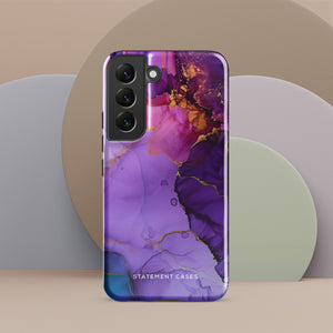 The Golden Orchid Marble for Samsung by Statement Cases is a smartphone adorned with a vibrant, abstract phone case showcasing a mix of purple, pink, and gold colors. Crafted from impact-resistant materials, it features a camera module with four lenses and a flash. At the bottom of the shock-absorbing phone case, you’ll find the text "STATEMENT CASES" in white.