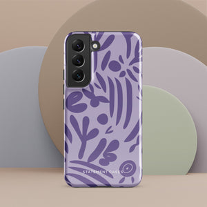 Introducing the Luna Morada for Samsung, a striking smartphone case from Statement Cases. This decorative purple cover boasts abstract floral and organic patterns in darker hues and is designed to absorb shocks. The impact-resistant case features a camera cutout that accommodates five lenses, with the brand name "STATEMENT CASES" elegantly printed at the bottom center.