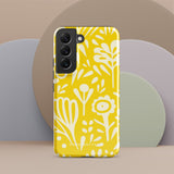 The Sol Dorado for Samsung by Statement Cases is a durable phone case featuring a bright yellow background adorned with an abstract white floral pattern, showcasing various flowers and leaves. Near the bottom edge, the text "STATEMENT CASE" highlights its dual-layer design for enhanced durability.