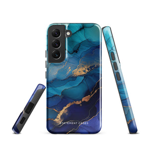 A Samsung smartphone adorned with the Midnight Wave Marble—a vibrant, blue and gold marble-patterned dual-layer phone case. Featuring multiple camera lenses at the top left corner, this impact-resistant case is elegantly labeled "Statement Cases" in white text at the bottom. The design showcases fluid, swirling layers with metallic accents.