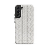 A stylish, impact-resistant phone case with a textured white braided design, covering the back of a smartphone. The dual-layer design features cutouts for the camera and buttons, and "Cozy Knit Bliss for Samsung" by Statement Cases is embossed at the bottom.