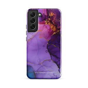 The Golden Orchid Marble for Samsung by Statement Cases is a smartphone adorned with a vibrant, abstract phone case showcasing a mix of purple, pink, and gold colors. Crafted from impact-resistant materials, it features a camera module with four lenses and a flash. At the bottom of the shock-absorbing phone case, you’ll find the text "STATEMENT CASES" in white.