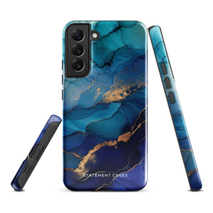 A Samsung smartphone adorned with the Midnight Wave Marble—a vibrant, blue and gold marble-patterned dual-layer phone case. Featuring multiple camera lenses at the top left corner, this impact-resistant case is elegantly labeled "Statement Cases" in white text at the bottom. The design showcases fluid, swirling layers with metallic accents.