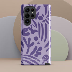 Introducing the Luna Morada for Samsung, a striking smartphone case from Statement Cases. This decorative purple cover boasts abstract floral and organic patterns in darker hues and is designed to absorb shocks. The impact-resistant case features a camera cutout that accommodates five lenses, with the brand name "STATEMENT CASES" elegantly printed at the bottom center.