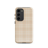 A smartphone with an impact-resistant beige plaid phone case featuring subtle light blue accents. The camera, flash, and sensor modules are visible at the top. The bottom part of the case has the text "Sophisticated Plaid for Samsung" printed on it by Statement Cases.