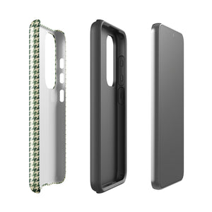 A smartphone with a green and white houndstooth patterned impact-resistant case is shown. The phone's camera module with multiple lenses is visible on the top left corner of the Elegance Houndstooth for Samsung shock-absorbing case by Statement Cases.