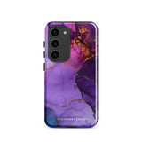 The Golden Orchid Marble for Samsung by Statement Cases is a smartphone adorned with a vibrant, abstract phone case showcasing a mix of purple, pink, and gold colors. Crafted from impact-resistant materials, it features a camera module with four lenses and a flash. At the bottom of the shock-absorbing phone case, you’ll find the text "STATEMENT CASES" in white.