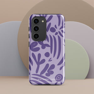 Introducing the Luna Morada for Samsung, a striking smartphone case from Statement Cases. This decorative purple cover boasts abstract floral and organic patterns in darker hues and is designed to absorb shocks. The impact-resistant case features a camera cutout that accommodates five lenses, with the brand name "STATEMENT CASES" elegantly printed at the bottom center.