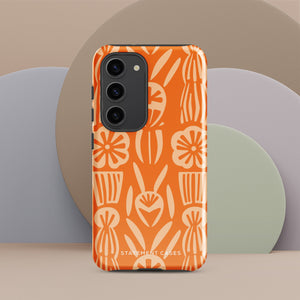 This stylish smartphone accessory, the Savannah Ardiente for Samsung by Statement Cases, features a shock-absorbing, colorful patterned case adorned with abstract flower designs in beige on an orange background. This impact-resistant phone case wraps around the back of your device, providing robust protection for its multiple camera lenses in the corner.