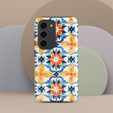 The Mediterranean Bloom for Samsung by Statement Cases features intricate, colorful floral patterns in blue, orange, and yellow. The design covers the entire back of the case, surrounding the camera cutout. Shock-absorbing and impact-resistant, it ensures protection while the brand "Statement Cases" is subtly printed near the bottom.