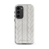 A stylish, impact-resistant phone case with a textured white braided design, covering the back of a smartphone. The dual-layer design features cutouts for the camera and buttons, and "Cozy Knit Bliss for Samsung" by Statement Cases is embossed at the bottom.