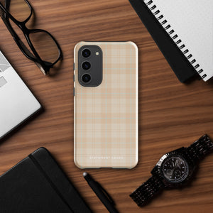 A smartphone with an impact-resistant beige plaid phone case featuring subtle light blue accents. The camera, flash, and sensor modules are visible at the top. The bottom part of the case has the text "Sophisticated Plaid for Samsung" printed on it by Statement Cases.