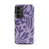 Introducing the Luna Morada for Samsung, a striking smartphone case from Statement Cases. This decorative purple cover boasts abstract floral and organic patterns in darker hues and is designed to absorb shocks. The impact-resistant case features a camera cutout that accommodates five lenses, with the brand name "STATEMENT CASES" elegantly printed at the bottom center.