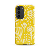 The Sol Dorado for Samsung by Statement Cases is a durable phone case featuring a bright yellow background adorned with an abstract white floral pattern, showcasing various flowers and leaves. Near the bottom edge, the text "STATEMENT CASE" highlights its dual-layer design for enhanced durability.