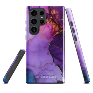 The Golden Orchid Marble for Samsung by Statement Cases is a smartphone adorned with a vibrant, abstract phone case showcasing a mix of purple, pink, and gold colors. Crafted from impact-resistant materials, it features a camera module with four lenses and a flash. At the bottom of the shock-absorbing phone case, you’ll find the text "STATEMENT CASES" in white.