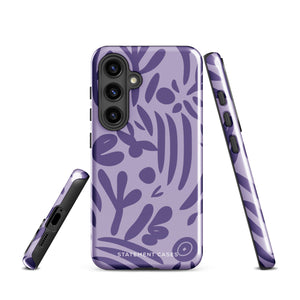 Introducing the Luna Morada for Samsung, a striking smartphone case from Statement Cases. This decorative purple cover boasts abstract floral and organic patterns in darker hues and is designed to absorb shocks. The impact-resistant case features a camera cutout that accommodates five lenses, with the brand name "STATEMENT CASES" elegantly printed at the bottom center.