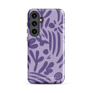 Introducing the Luna Morada for Samsung, a striking smartphone case from Statement Cases. This decorative purple cover boasts abstract floral and organic patterns in darker hues and is designed to absorb shocks. The impact-resistant case features a camera cutout that accommodates five lenses, with the brand name "STATEMENT CASES" elegantly printed at the bottom center.