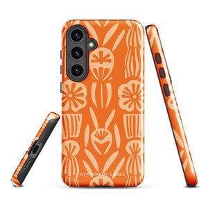 This stylish smartphone accessory, the Savannah Ardiente for Samsung by Statement Cases, features a shock-absorbing, colorful patterned case adorned with abstract flower designs in beige on an orange background. This impact-resistant phone case wraps around the back of your device, providing robust protection for its multiple camera lenses in the corner.