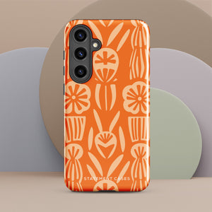 This stylish smartphone accessory, the Savannah Ardiente for Samsung by Statement Cases, features a shock-absorbing, colorful patterned case adorned with abstract flower designs in beige on an orange background. This impact-resistant phone case wraps around the back of your device, providing robust protection for its multiple camera lenses in the corner.