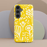 The Sol Dorado for Samsung by Statement Cases is a durable phone case featuring a bright yellow background adorned with an abstract white floral pattern, showcasing various flowers and leaves. Near the bottom edge, the text "STATEMENT CASE" highlights its dual-layer design for enhanced durability.