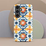 The Mediterranean Bloom for Samsung by Statement Cases features intricate, colorful floral patterns in blue, orange, and yellow. The design covers the entire back of the case, surrounding the camera cutout. Shock-absorbing and impact-resistant, it ensures protection while the brand "Statement Cases" is subtly printed near the bottom.