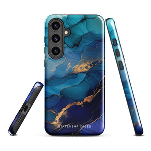 A Samsung smartphone adorned with the Midnight Wave Marble—a vibrant, blue and gold marble-patterned dual-layer phone case. Featuring multiple camera lenses at the top left corner, this impact-resistant case is elegantly labeled "Statement Cases" in white text at the bottom. The design showcases fluid, swirling layers with metallic accents.