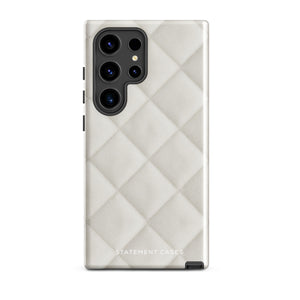 A Quilted Delight for Samsung with a quilted pattern in a light cream color made from impact-resistant materials. The case has a cutout for the camera module with four lenses and a flash. "Statement Cases" is branded at the bottom in white text.