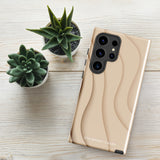 A Sandy Serenity for Samsung encased in a beige, impact-resistant phone case with wavy, textured patterns. Four camera lenses are visible on the back. The lower part of the dual-layer design case displays the text "Statement Cases.