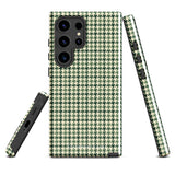 A smartphone with a green and white houndstooth patterned impact-resistant case is shown. The phone's camera module with multiple lenses is visible on the top left corner of the Elegance Houndstooth for Samsung shock-absorbing case by Statement Cases.