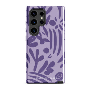 Introducing the Luna Morada for Samsung, a striking smartphone case from Statement Cases. This decorative purple cover boasts abstract floral and organic patterns in darker hues and is designed to absorb shocks. The impact-resistant case features a camera cutout that accommodates five lenses, with the brand name "STATEMENT CASES" elegantly printed at the bottom center.